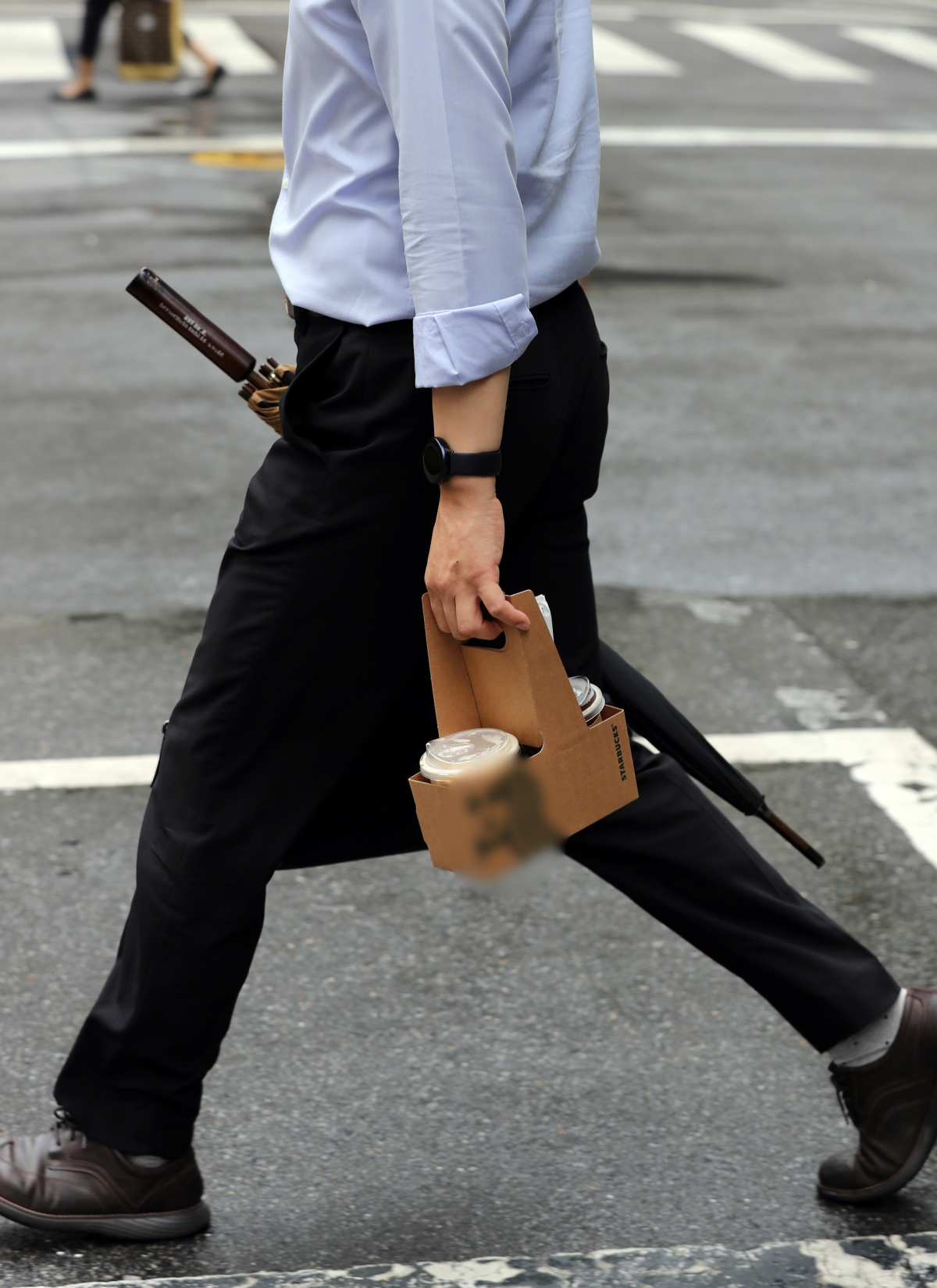 ▲수도권 프랜차이즈형 커피전문점은 30일부터 영업시간과 관계없이 포장·배달만 허용된다. 한 직장인이 28일 서울 시내 한 프랜차이즈 카페에서 커피를 포장(테이크아웃)해 이동하고 있다. (뉴시스)