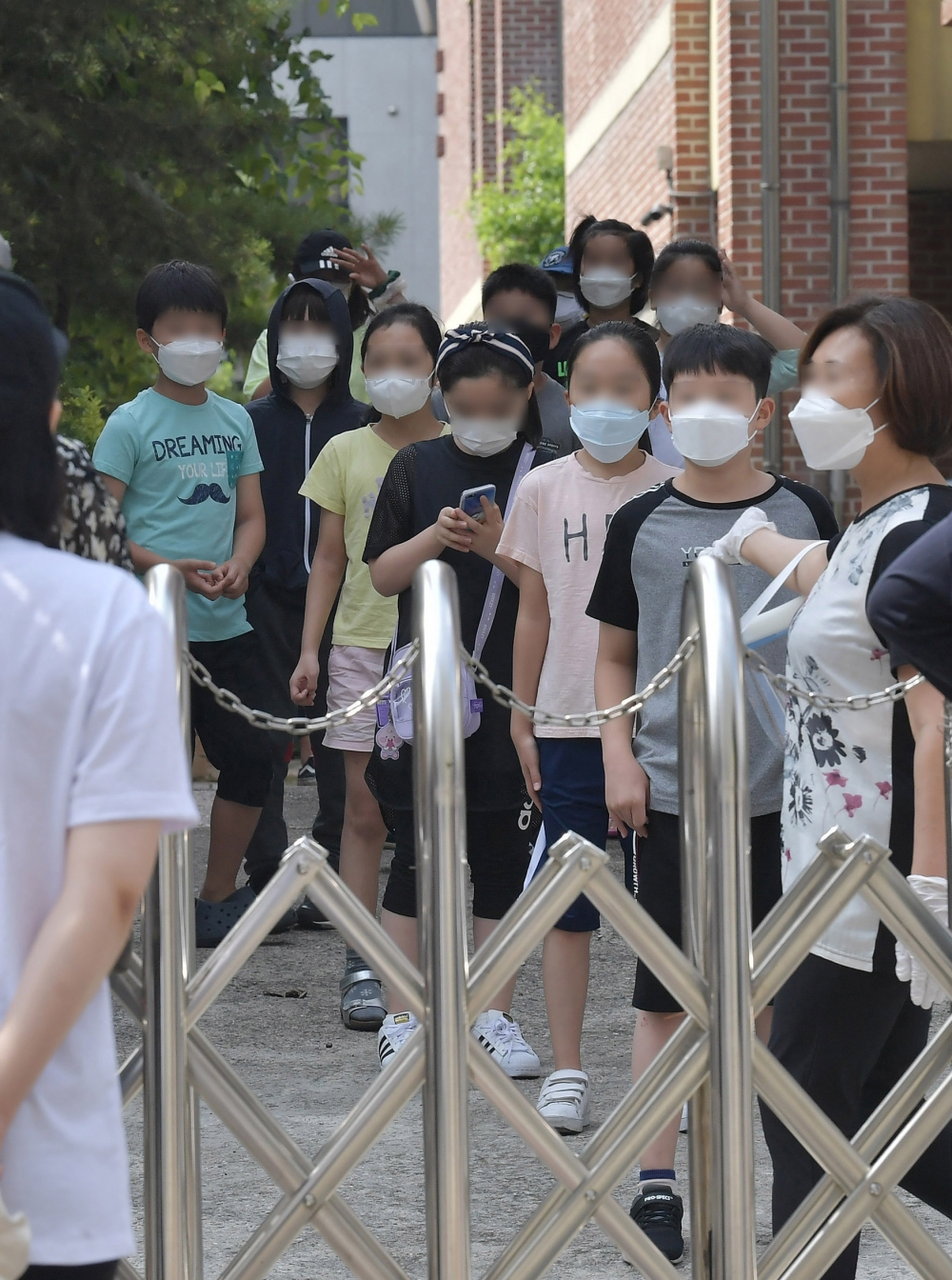 ▲5일 서울 중랑구 묵현초에 마련된 임시 선별진료소에서 학생들이 신종 코로나바이러스 감염증(코로나19) 검사를 받기 위해 줄지어 기다리고 있다. 묵현초에 재학중인 한 학생이 지난 4일 코로나19 확진 판정을 받았으며 중랑구는 묵현초 전체 학생과 교직원에 대해 이날 선별진료소에서 전수검사를 실시했다. 신태현 기자 holjjak@ (이투데이DB)