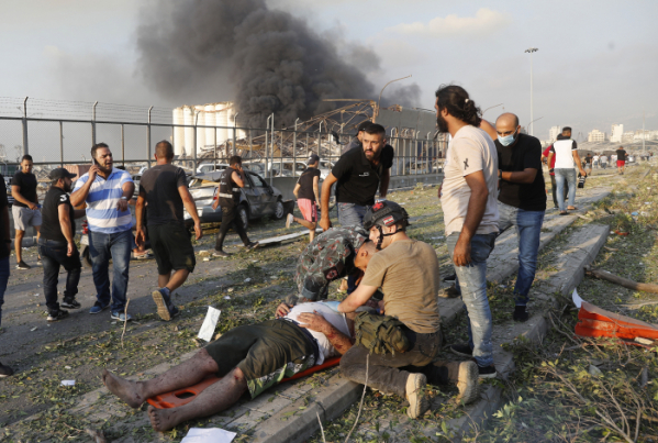 ▲4일(현지시간) 레바논 수도 베이루트 항구의 대규모 폭발 현장 인근에서 한 부상자를 구조중이다. (AP/연합뉴스)