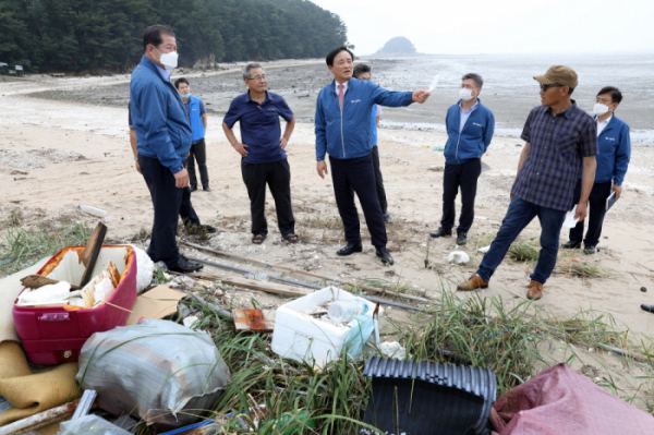 ▲임준택 수협 회장이 12일 한강 하구 지역 어촌을 방문해 육상에서 흘러온 쓰레기를 살펴보고 있다. (사진제공=수협중앙회)