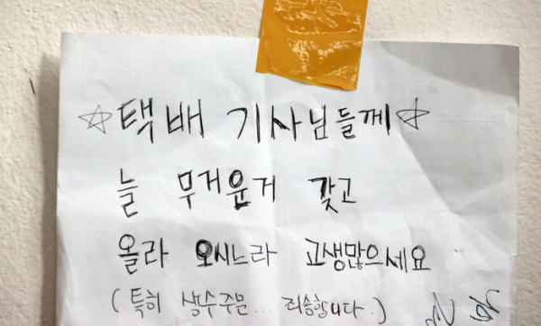▲13일 서울 시내의 한 빌라 복도에 택배 기사에게 전하는 메모와 음료수가 놓여있다. (연합뉴스)