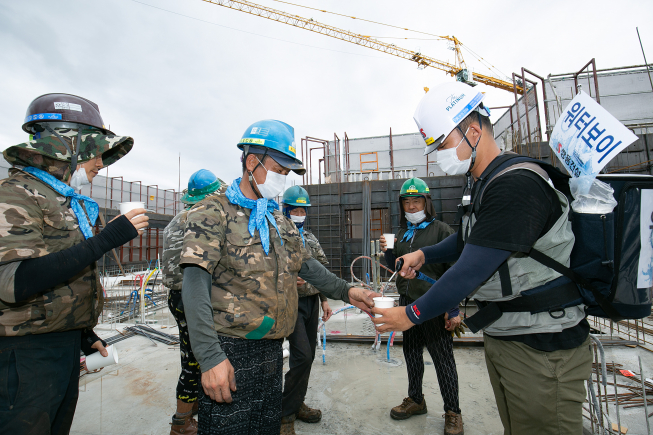 ▲경기 광주시 초월읍 ‘쌍용 더 플래티넘 광주’ 아파트 현장 보건관리자가 근로자들에게 얼음물을 나눠주고 있다. (사진제공=쌍용건설)