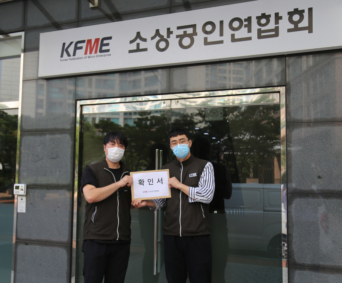 ▲김효진 소상공인연합회 노동조합 부위원장(왼쪽부터)과 장기수 노조위원장이 사측에 사무국 조직개편안 수용불가 확인서를 전달하고 있다. (사진제공=소상공인연합회 노동조합)