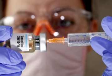 ▲한 여성이 코로나19 백신 스티커가 붙은 작은 병과 의료용 주사기를 들고 있다. 로이터연합뉴스
