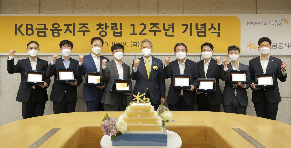 ▲윤종규(가운데) KB금융 회장이 창립 12주년 유튜브 생중계 기념식에서 장기근속직원들과 기념사진을 찍고 있다. (KB금융)