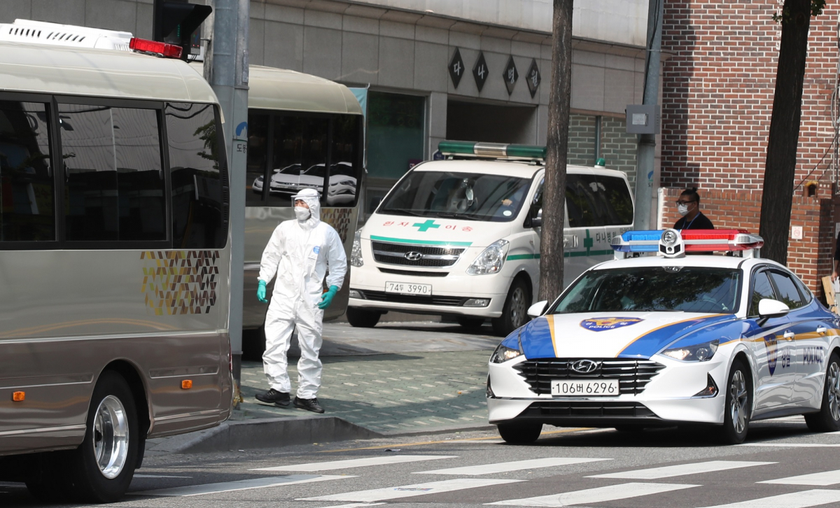 ▲30일 오전 신종 코로나 바이러스 감염증(코로나19) 집단감염으로 병원 전체가 코호트 격리(동일집단 격리)된 서울 도봉구 다나병원에서 재검사 대상자들을 태운 차량과 경찰 차량이 이동하고 있다. (뉴시스)