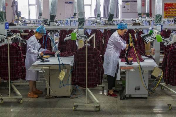 ▲중국 장쑤성 하이안시의 한 의류공장에서 지난달 27일(현지시간) 근로자들이 셔츠를 다리고 있다. 하이안/AP뉴시스 
