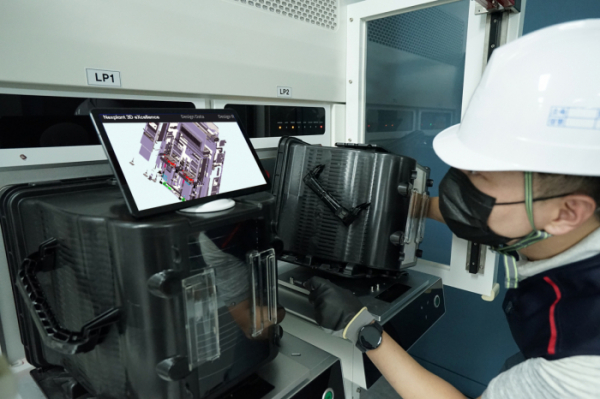 ▲현장엔지니어가 태블릿PC를 통해 넥스플랜트 3D 엑설런스로 제작한 3D 디지털 매뉴얼을 보면서 작업하고 있다 . (사진제공=삼성SDS)