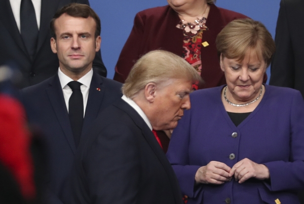 ▲도널드 트럼프(가운데) 미국 대통령이 지난해 12월 4일(현지시간) 영국 왓포드에서 열린 북대서양조약기구(NATO·나토) 정상회의 기간 단체 기념사진을 찍기 위해 에마뉘엘 마크롱(왼쪽) 프랑스 대통령과 앙겔라 메르켈 독일 총리 앞을 지나가고 있다. 왓포드/AP뉴시스 
