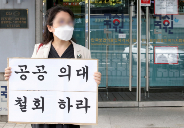 ▲10일 오후 한 전공의가 서울 광진구 한국보건의료인국가시험원 본관 앞에서 공공의대 정책 철회를 요구하는 1인 시위를 하고 있다. (뉴시스)