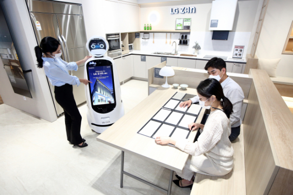 ▲LG하우시스가 서울 논현동 가구거리에 위치한 플래그십 전시장 'LG Z:IN 스퀘어'에 LG전자의 자율주행 안내로봇 'LG 클로이 안내로봇'을 도입했다. LG지인 스퀘어를 방문한 고객들이 'LG 클로이 안내로봇'의 설명을 들으며 주방공간을 살펴보고 있다.  (사진제공=LG하우시스)