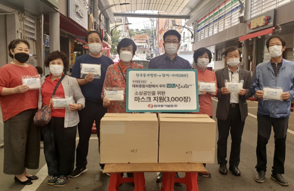 ▲신용민 한국동서발전 사회공헌부장(왼쪽에서 다섯 번째)이 17일 울산 본사 인근에 있는 태화종합시장을 찾아 마스크를 전달한 후 기념 촬영을 하고 있다.  (사진제공=한국동서발전)