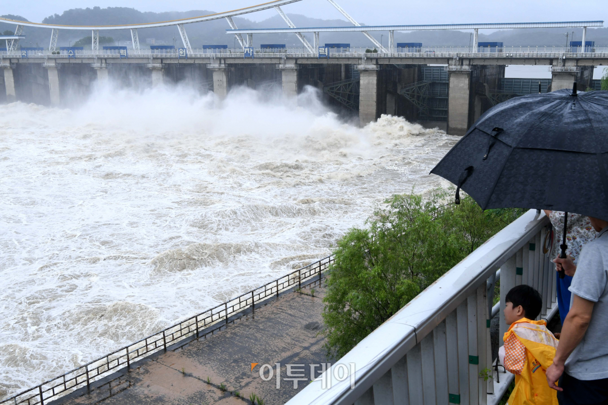 ▲올해 중부지방 장마는 54일 동안 지속되면서 최장기간 기록을 경신했다. 지난 8월, 집중호우로 수문을 열고 방류 중인 경기도 하남시 팔당댐에서 시민들이 흙탕물이 쏟아져나오는 모습을 바라보고 있다.  (신태현 기자 holjjak@)