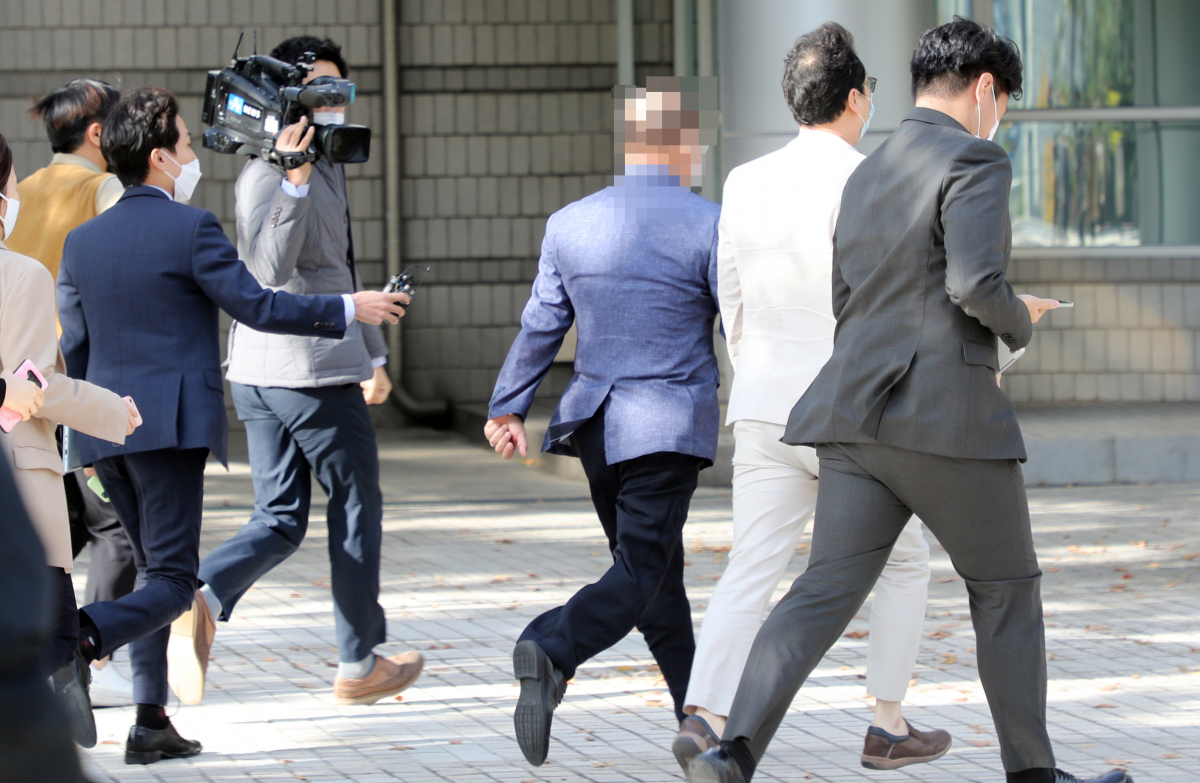 ▲옵티머스자산운용의 정관계 로비 의혹에 연루돼 검찰 수사를 받는 윤모 금융감독원 전 국장이 다른 건의 뒷돈 수수 혐의로 항소심 첫 재판을 받은 후 기자들의 질문을 받으며 서울중앙지법을 나서고 있다. (연합뉴스)