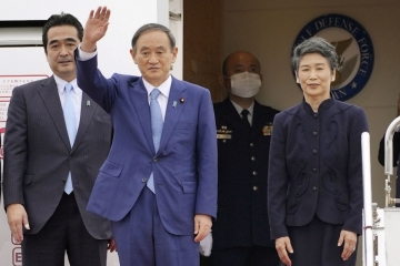 ▲스가 요시히데 일본 총리가 18일 도쿄 하네다 국제 공항에서 베트남과 인도네시아로 떠날 때 부인인 스가 마리코 여사 옆에서 손을 흔들고 있다. 도쿄/교도·로이터연합뉴스
