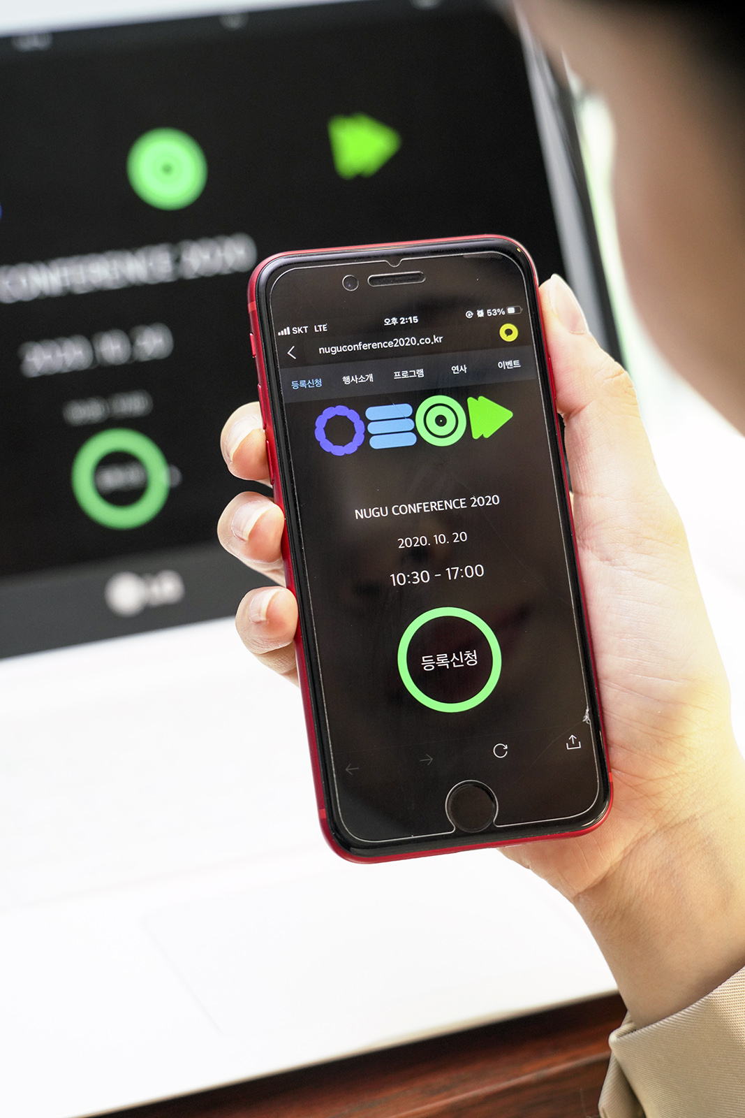 ▲모델이 스마트폰을 사용해 ‘누구 컨퍼런스 2020’ 참가 등록을 하고 있다. (사진제공=SKT)