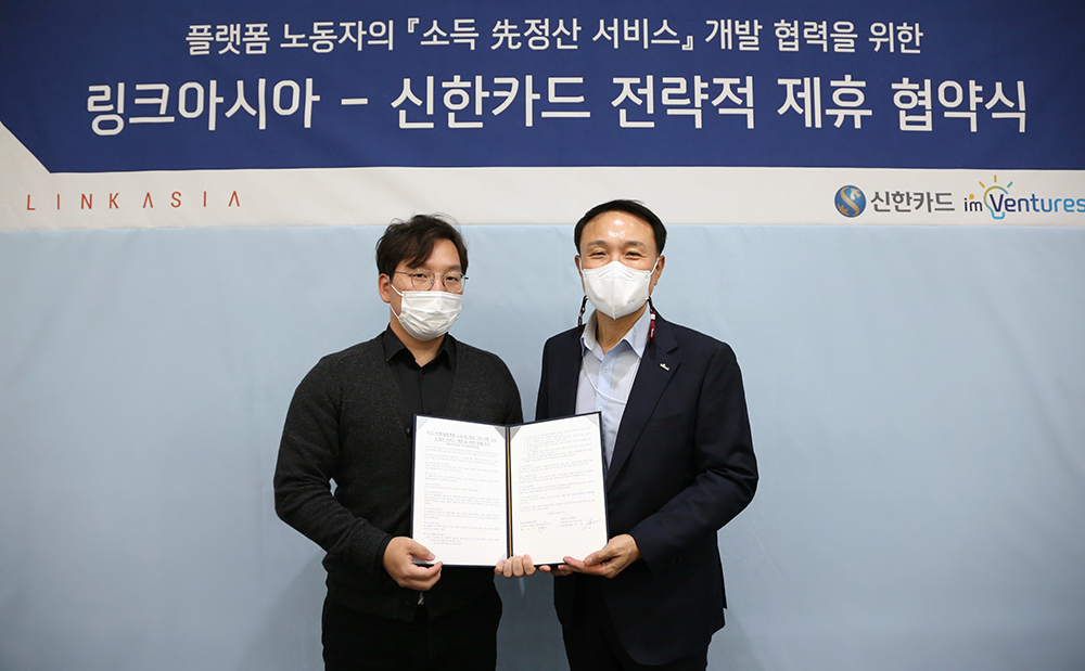 ▲20일 신한카드는 링크아시아매니지먼트와 카드기반 소득 선정산 서비스 협업을 위해 서울 을지로에 위치한 신한카드 본사에서 전략적 제휴 협약식을 진행했다. 조윤호 링크아시아 대표(왼쪽)와 문동권 신한카드 경영기획그룹장(오른쪽)이 제휴 협약서를 들고 기념촬영을 하고 있다. (사진제공=신한카드)