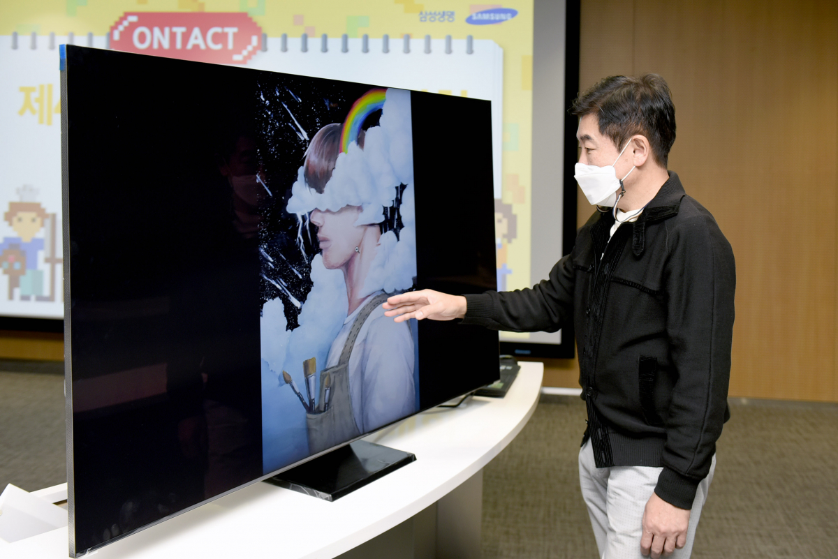 ▲한 심사위원이 서울 서초동에 위치한 삼성생명 컨퍼런스룸에서 삼성 QLED 8K TV를 활용해 예선작품을 심사하고 있다.  (사진제공=삼성전자)