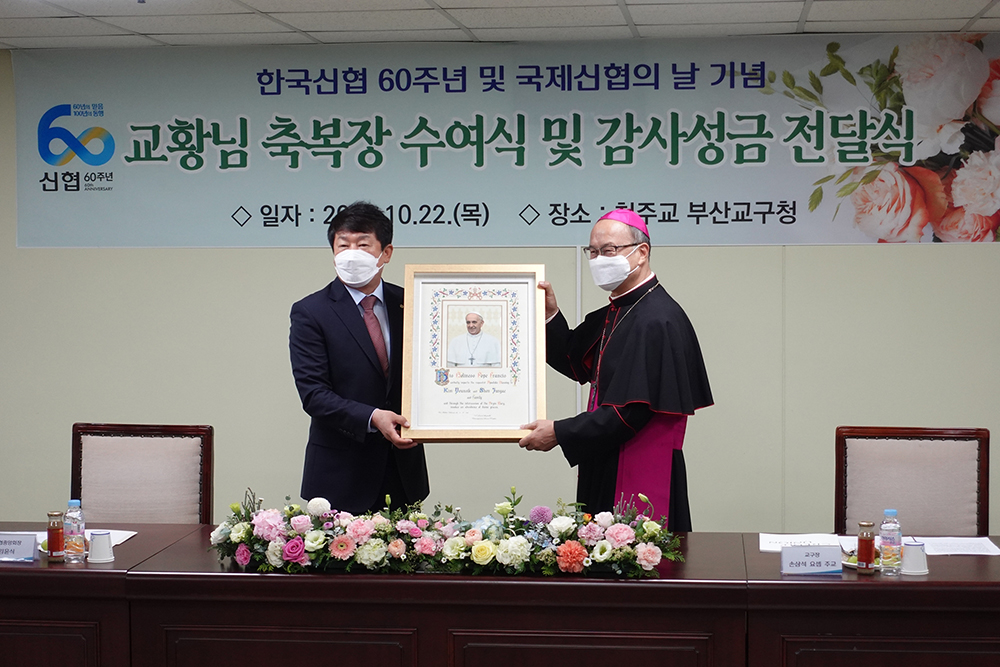 ▲김윤식 신협중앙회장(왼쪽)이 1300만 신협 이용자와 임직원을 대표해 천주교 부산교구청 손삼석 요셉 주교로부터 프란치스코 교황 축복장을 받았다. (사진제공=신협중앙회)