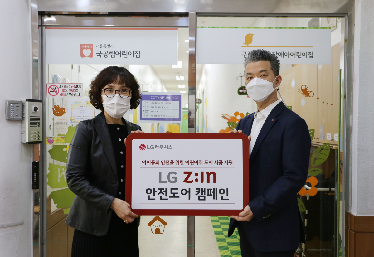 ▲김경애(왼쪽) 아나율 장애아 어린이집 원장과 유석희 LG하우시스 브랜드마케팅 팀장이 23일 문 교체를 끝내고 기념사진을 찍고 있다. (사진제공=LG하우시스)