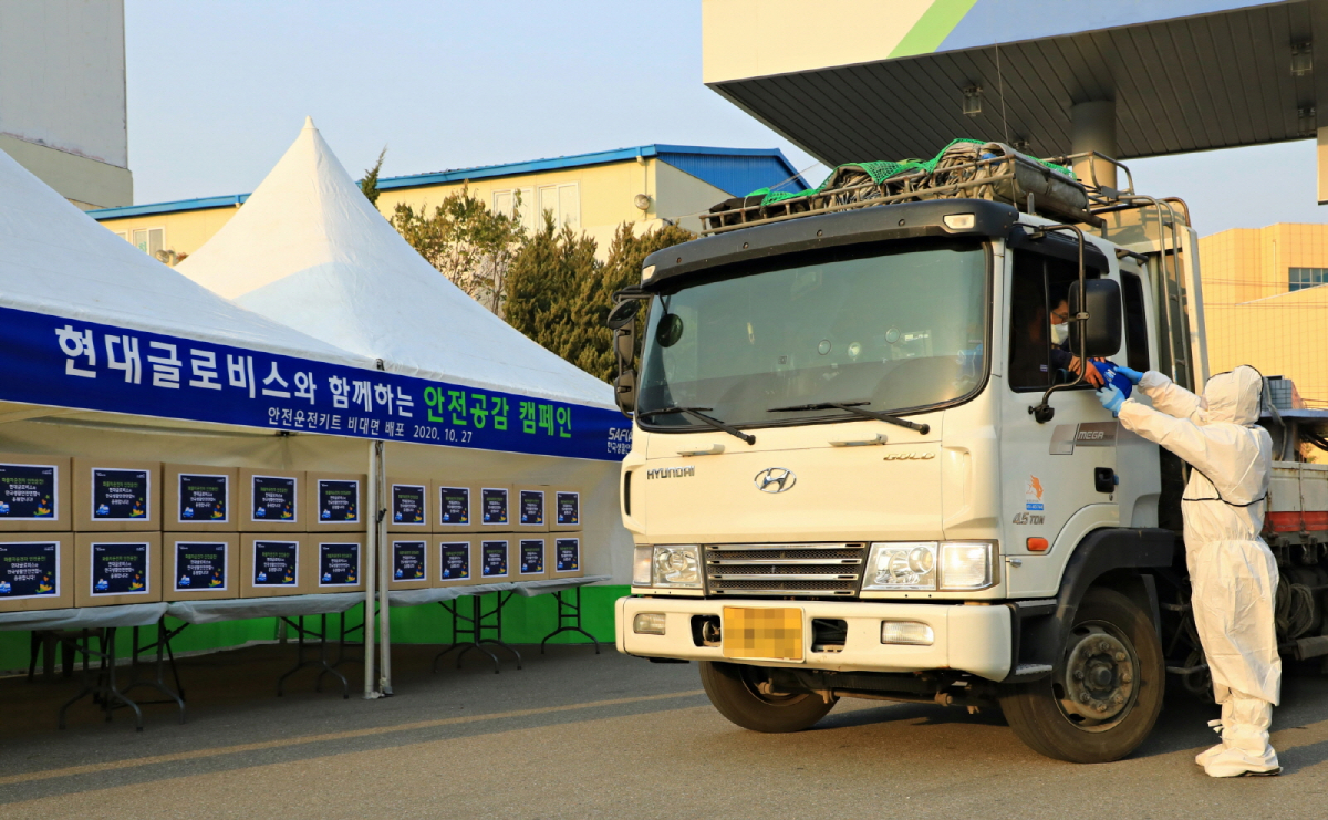 ▲현대글로비스 관계자가 27일 청주화물터미널을 이용하는 화물차 운전자에게 안전운전용품 세트를 드라이브 스루 방식으로 전달하고 있다.  (사진제공=현대글로비스)