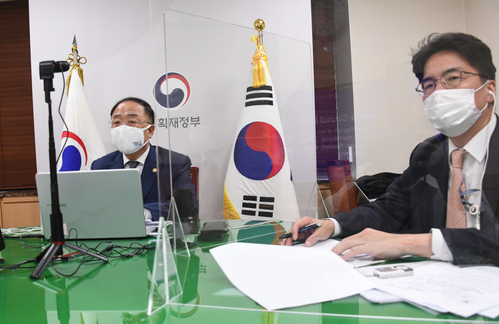 ▲홍남기 경제부총리 겸 기획재정부 장관이 10월 29일 서울 광화문 정부서울청사에서 화상으로 열린 'OECD(경제협력개발기구) 각료이사회 전체회의'에 참석하고 있다. 오른쪽은 윤태식 국제경제관리관. (사진제공=기획재정부)
