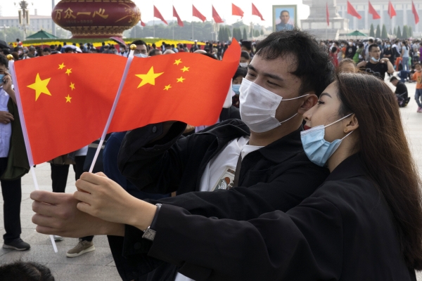 ▲중국 베이징 톈안먼 광장에서 1일(현지시간) 한 여행객 커플이 중국 국기를 들고 셀카를 찍고 있다. 베이징/AP뉴시스 