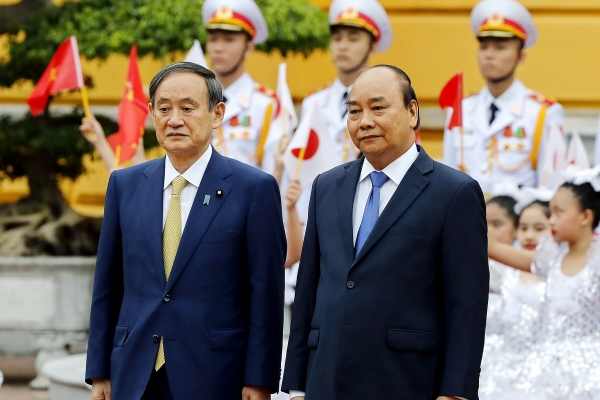▲스가 요시히데(왼쪽) 일본 총리가 19일 베트남을 방문해 응우옌 쑤언 푹 베트남 총리와 정상회담 전 의장대를 사열하고 있다. 하노이/AP뉴시스
