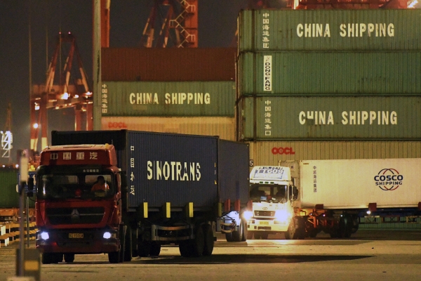 ▲중국 칭다오 항구에서 9월 25일 트럭들이 컨테이너들을 옮기고 있다. 칭다오/AP뉴시스

