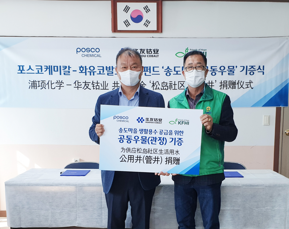 ▲민경준(왼쪽) 포스코케미칼 사장과 이기전 송도마을 이장이 전남 여수 송도에서 우물 공사를 마치고 열린 기증식에서 기념사진을 찍고 있다. (사진제공=포스코케미칼)