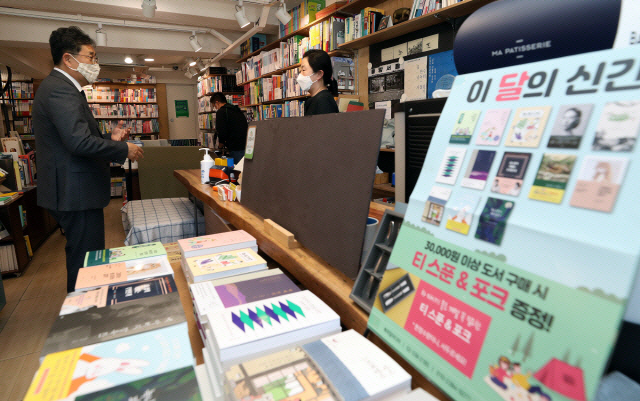 ▲박양우 문화체육관광부 장관이 5월 13일 서울 혜화동의 동양서림에서 책을 구매한 후 계산을 하면서 직원과 대화하고 있다. (사진제공=문화체육관광부)