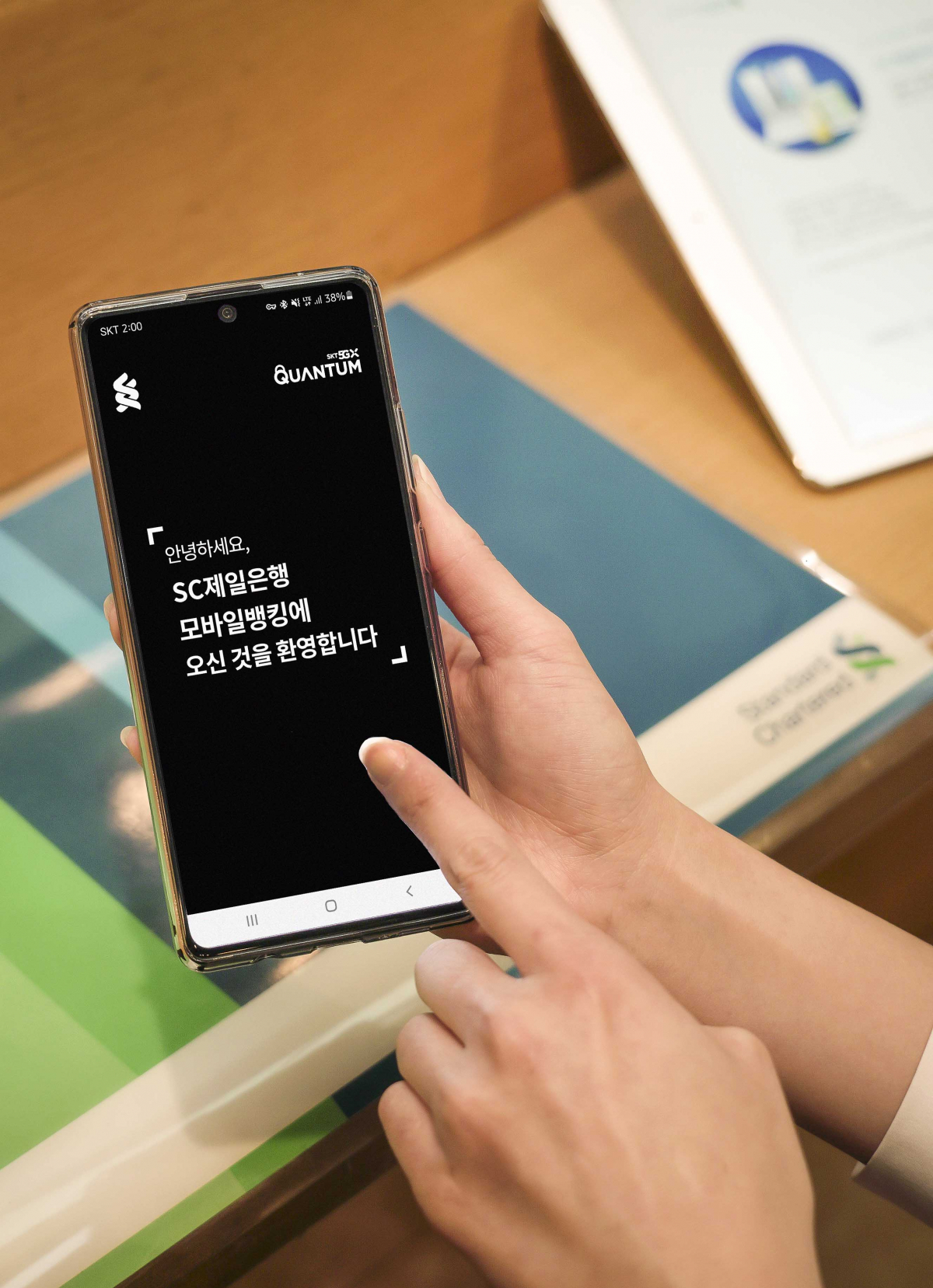 ▲SKT 모델이 양자보안 모바일 OTP(6자리 숫자)로 다양한 금융 거래를 안전하게 할 수 있는 SC제일은행 모바일뱅킹 앱을 소개하고 있다. (사진제공=SKT)