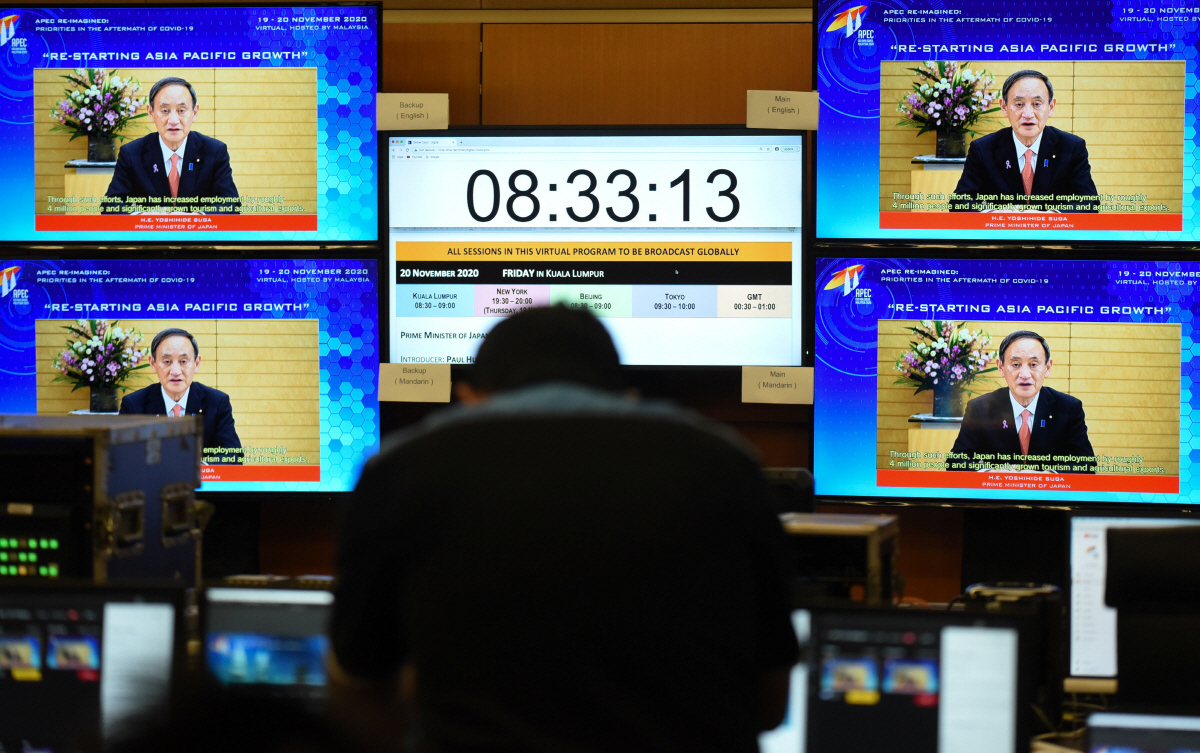 ▲아시아·태평양경제협력체(APEC) 정상회의가 20일 말레이시아 쿠알라룸푸르에서 화상으로 개최되기에 앞서 이날 현지 회담 지휘센터 모니터에 스가 요시히데 일본 총리가 APEC 관련 행사인 ‘CEO와의 대화’에 보낸 화상 메시지가 방영되고 있다. 쿠알라룸푸르/로이터연합뉴스