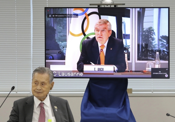 ▲모리 요시로(왼쪽) 도쿄올림픽 조직위원회 위원장과 토마스 바흐 국제올림픽위원회(IOC) 위원장이 9월 24일 화상회의를 하는 중에 바흐 위원장 모습이 오른쪽 화면에 비추고 있다. 도쿄/AP뉴시스
