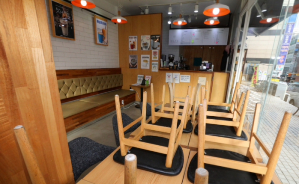 ▲ 24일 오후 사회적 거리두기 2단계가 시행됨에 따라 서울 서초구의 한 카페에 의자들이 테이블 위로 올라가 있다. 2단계 방역조치가 시행되면 카페는 포장과 배달만 허용된다.  (뉴시스)