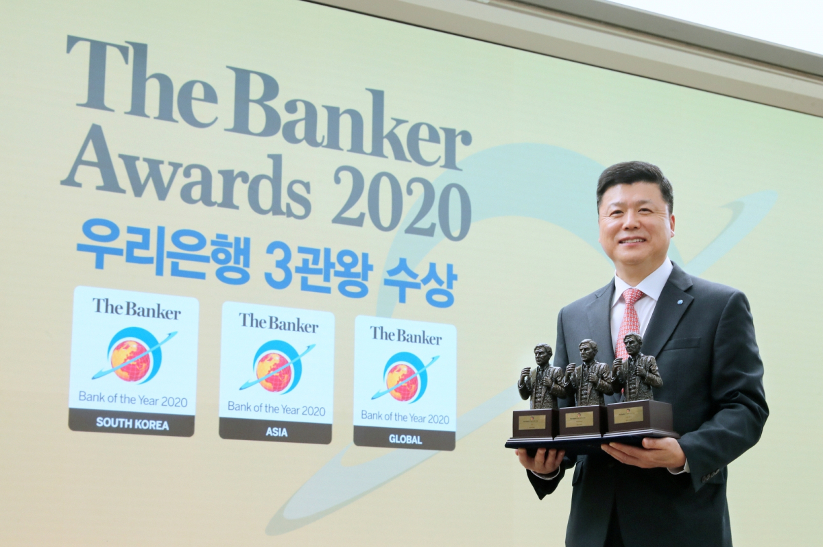 ▲권광석 우리은행장이 온라인으로 진행된 더 뱅커(The Banker)의 '올해의 은행(THE BANK OF THE YEAR’) 시상식에서 글로벌 최우수 은행, 아시아 최우수 은행, 한국 최우수 은행 등 3개 부문 트로피를 들고 기념 촬영을 하고 있다. (사진제공=우리은행)