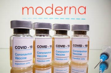 ▲미국 제약사 모더나 로고 앞에 ‘COVID-19 / 코로나 바이러스 백신/주입 전용’이라는 스티커가 붙은 병과 의료용 주사기가 놓여 있다. 로이터연합뉴스
