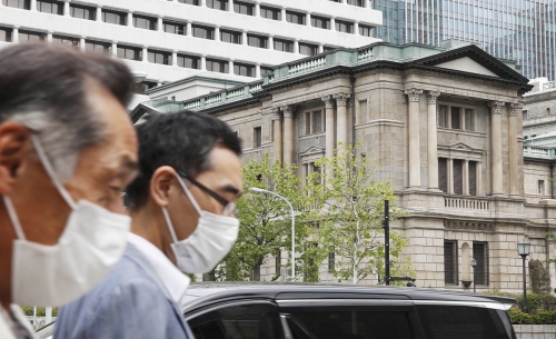 ▲일본 도쿄에서 4월 27일 마스크를 쓴 행인들이 일본은행 본점 앞을 지나가고 있다. 일본은행이 18일 기업 자금 지원을 연장하고 금융완화 정책을 유지하겠다고 발표했다. 도쿄/AP뉴시스
