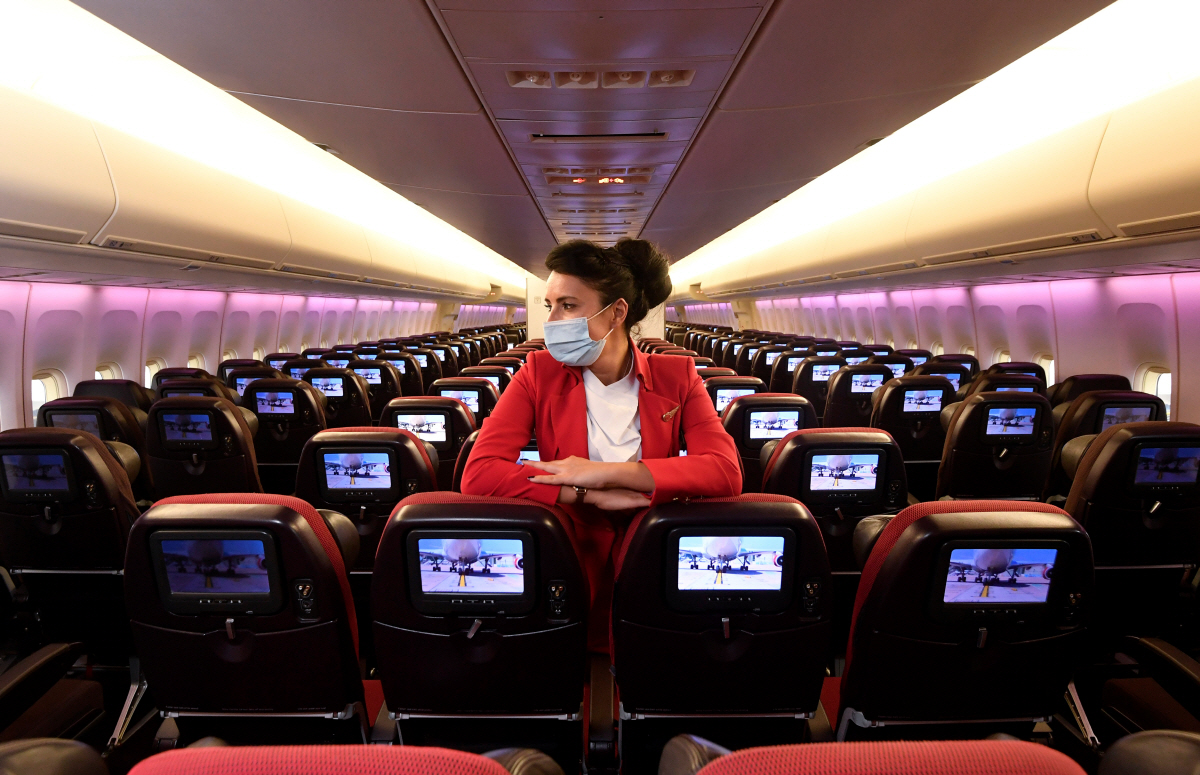 ▲영국 런던 히드로공항에서 12월 11일 대기 중인 버진애틀랜틱 여객기에서 한 승무원이 마스크를 낀 채 텅빈 기내를 둘러보고 있다. 런던/로이터연합뉴스
