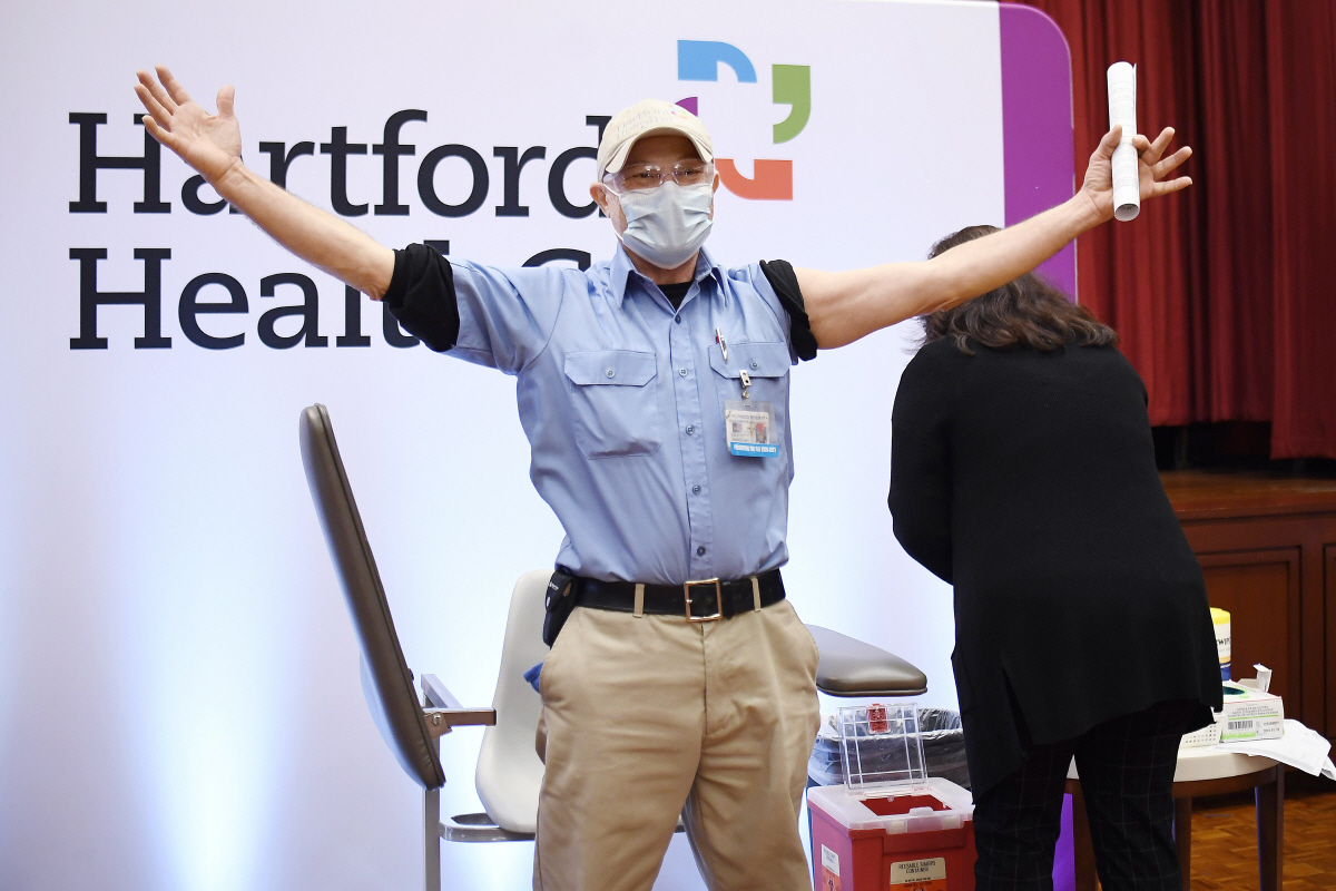 ▲미국 코네티컷주의 하트퍼드헬스케어 병원에서 21일(현지시간) 모더나가 개발한 신종 코로나바이러스 감염증(코로나19) 백신을 맞은 직원이 두 팔을 들면서 기쁨을 표시하고 있다. 하트퍼드/AP연합뉴스 
