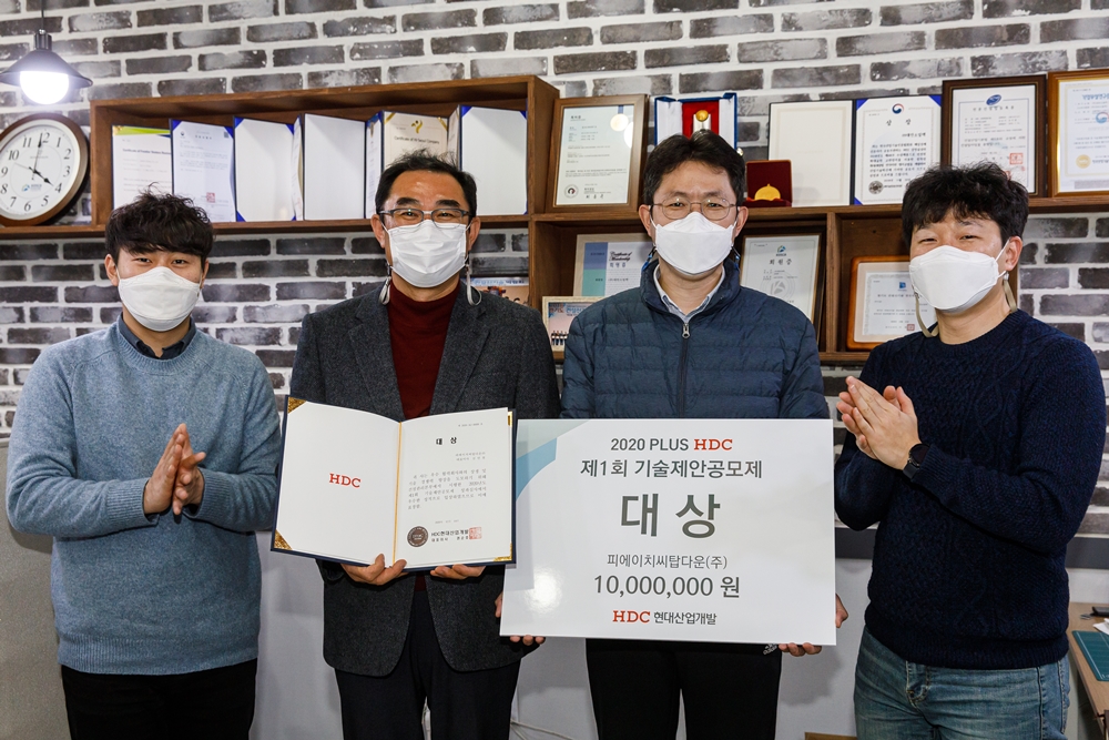 ▲HDC현대산업개발이 주최한 1회 '기술제안공모제' 비대면 시상식에서 대상을 수상한 피에이치씨탑다운의 김인철 대표(왼쪽에서 두 번째)가 직원들과 함께 기념촬영을 하고 있다. (사진제공=HDC현대산업개발)