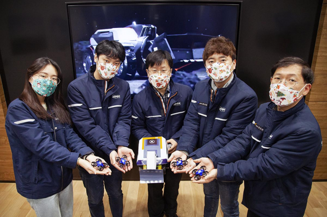 ▲두산인프라코어 임직원들이 온라인 주니어공학교실 진행에 앞서 ‘컨셉트-엑스’ 교보재를 가지고 기념사진을 촬영하고 있다. (사진제공=두산인프라코어)