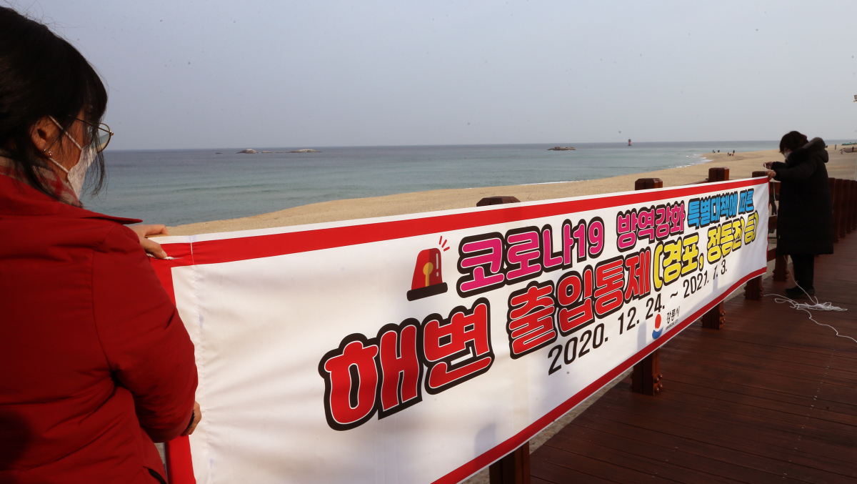 ▲연말연시 해맞이 관광객에 의한 코로나19 대확산이 우려되자 23일 강원 강릉시가 경포 해변 주변에 출입을 차단한다는 현수막을 걸고 있다. (연합뉴스)