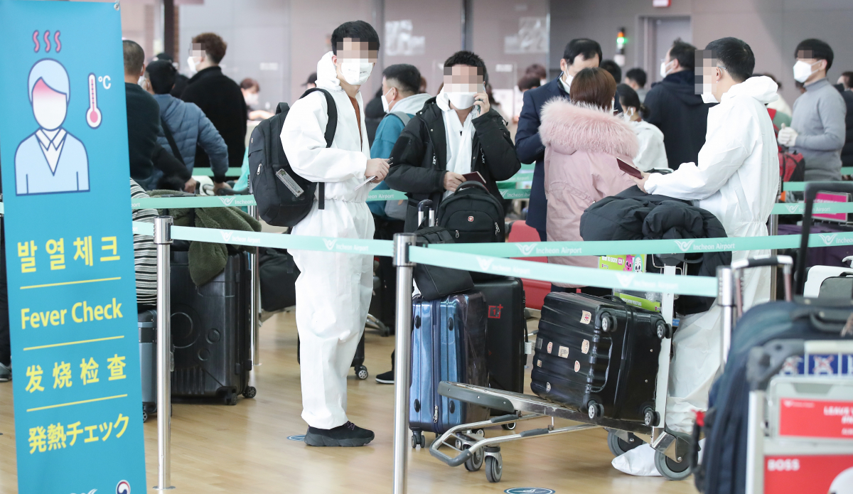 ▲28일 오전 인천국제공항 2터미널 출국장에서 방호복을 입은 출국객들이 수속을 위해 대기하고 있다.  (연합뉴스)
