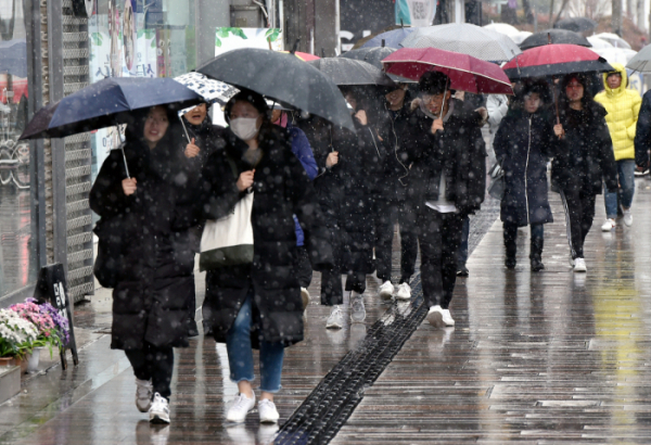 ▲비와 눈이 섞여 내리고 있는 대구 중구 약정골목 거리에서 시민들이 우산을 쓰고 발걸음을 재촉하고 있다.  (사진 출처=뉴시스)