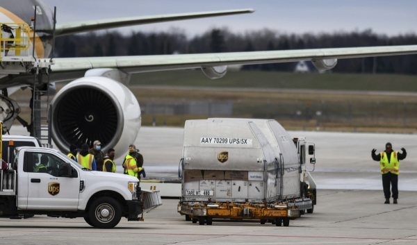 ▲물류업체 UPS 직원이 13일(현지시간) 미시간주 랜싱 국제공항에서 화이자 백신을 비행기로 옮기고 있다. 랜싱/AP뉴시스
