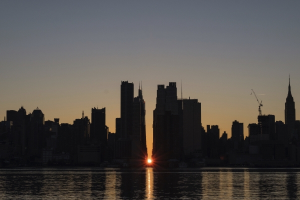 ▲미국 뉴욕 맨해튼 자치구의 42번가 건물 가운데에서 태양이 솟아오르고 있다. 맨해튼/AP연합뉴스
