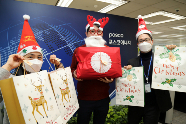 ▲포스코에너지 직원들이 인천 서구 지역아동센터 어린이들에게 ‘맞춤형 크리스마스 선물’을 전달하기 전에 직접 포장한 선물 꾸러미를 들고 사진을 찍고 있다. (사진제공=포스코에너지)