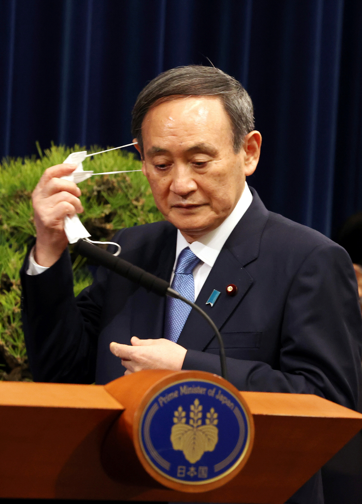 ▲스가 요시히데 일본 총리가 4일 도쿄 총리관저에서 열린 신년기자회견에 도착해 마스크를 벗고 있다. 도쿄/로이터연합뉴스