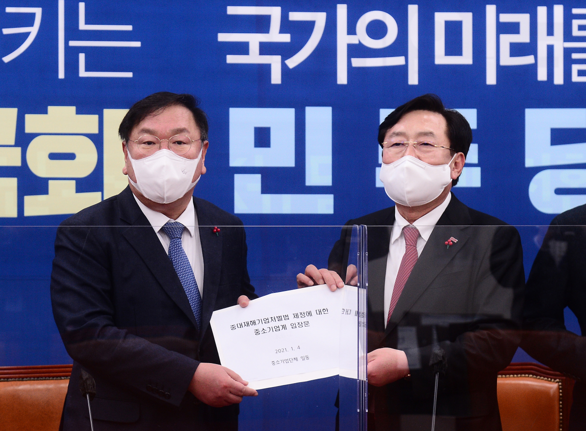 ▲더불어민주당 김태년 원내대표가 4일 오후 서울 여의도 국회에서 열린 중대재해법 관련 중소기업단체 간담회에서 김기문 중소기업중앙회 회장으로 부터 '중대재해기업처벌법 제정에 대한 중소기업계 입장문'을 전달받고 있다.  (연합뉴스)